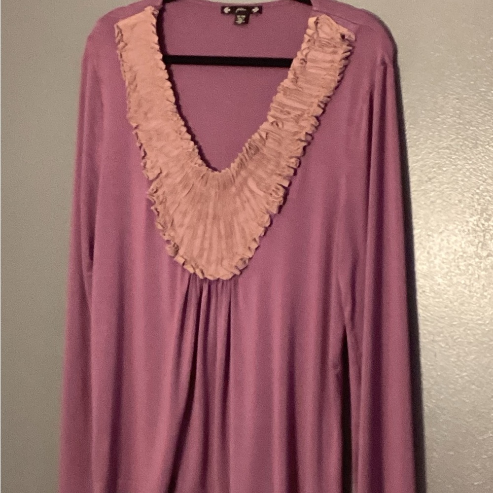 Women’s long sleeve top with low wide ruffle around neck.